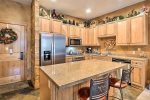Large kitchen with granite countertops and island with bar seating